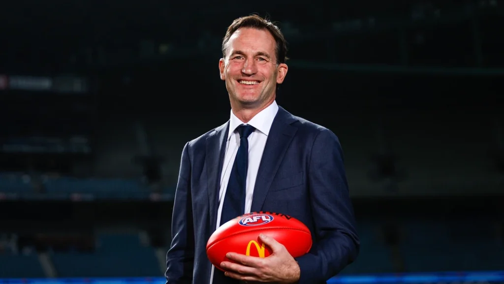 Portrait of Andrew Dillon holding an AFL Football.